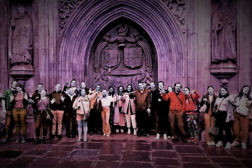 Un groupe de personnes se tient devant une arche gothique ornée de statues. 2