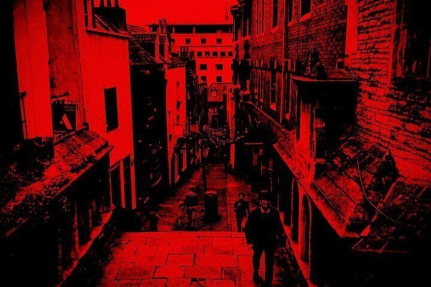 A narrow alleyway with buildings on either side, a person walking down the center, and a distant building at the end. 3