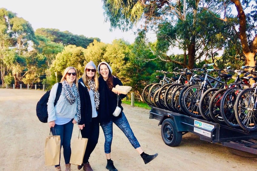 Three people walking past a bicycle rack in a park. 5
