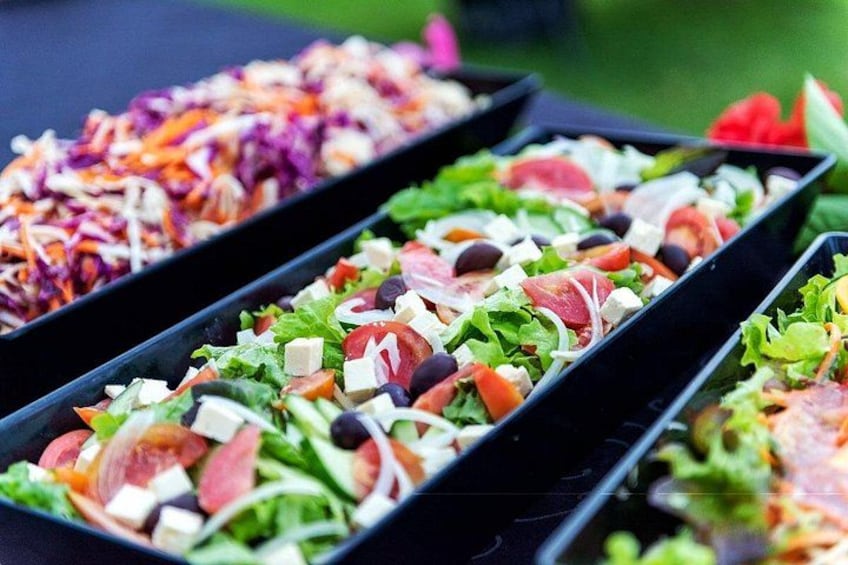 A variety of salads in black trays. 1