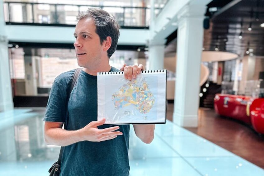 A person holding a map in a modern indoor space with glass flooring and red seating. 3