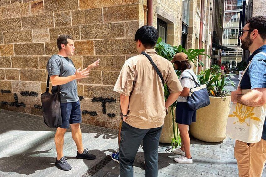 A group of people standing on a sidewalk, engaged in conversation. 4