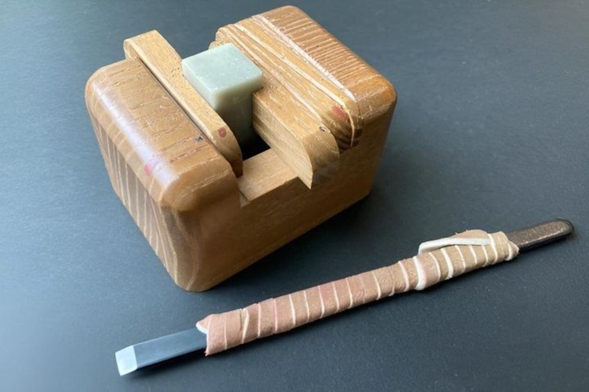 A wooden object with a handle and a metal tool. 4