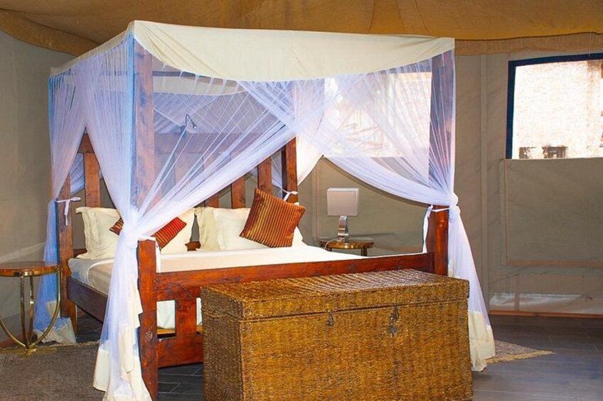 A four-poster bed with a canopy, a bedside table, and a wicker chest of drawers. 3