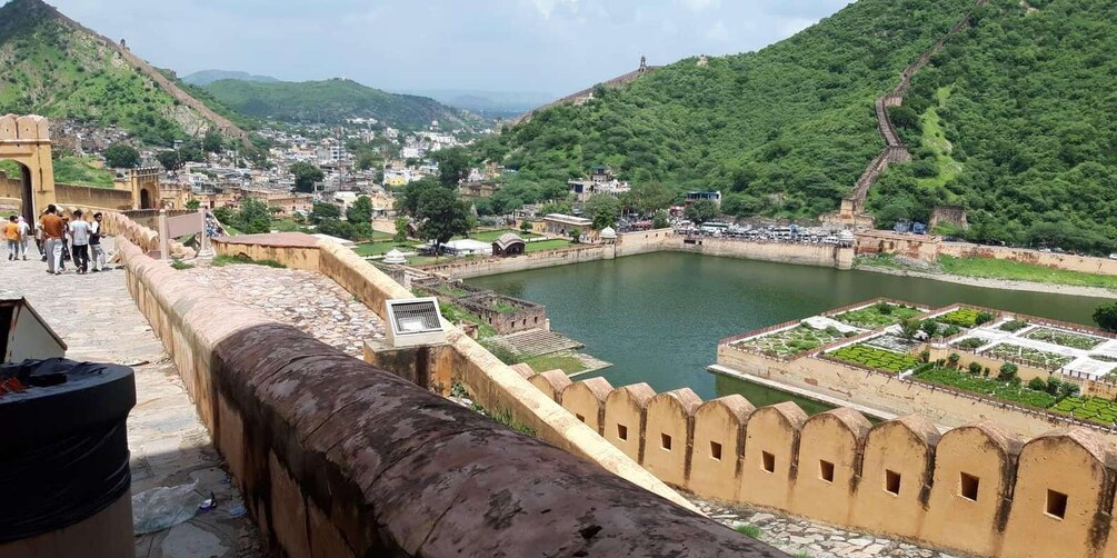 A historic fort overlooking a river with lush greenery and a town in the background. 4