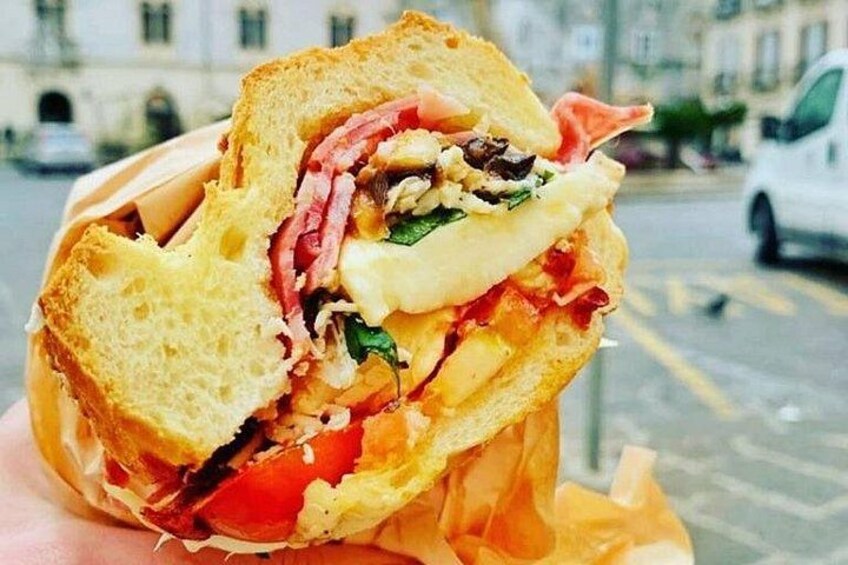 A sandwich with visible ingredients like lettuce, tomato, and cheese. 2