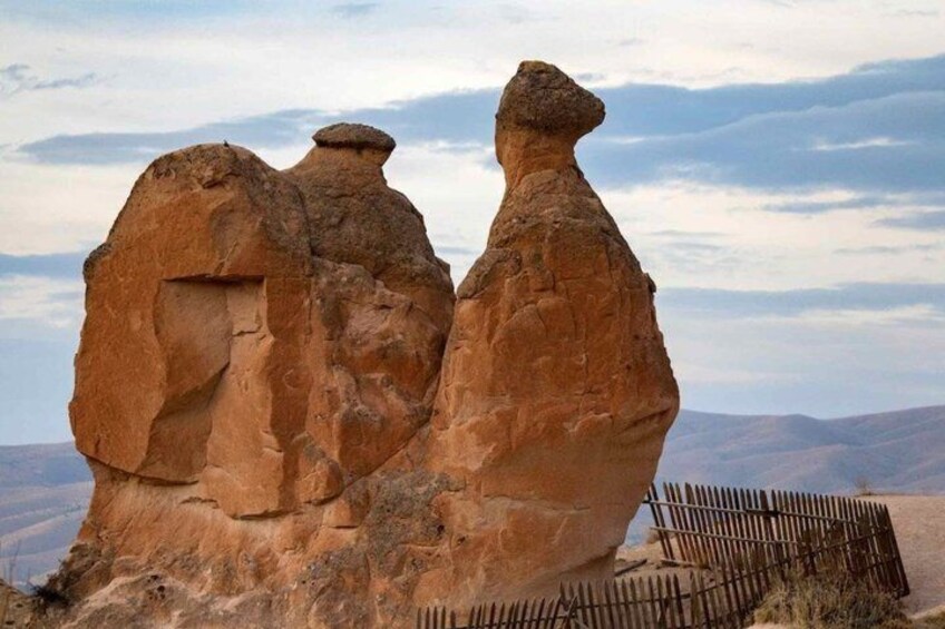 A rock formation with a wooden fence in the foreground. 5