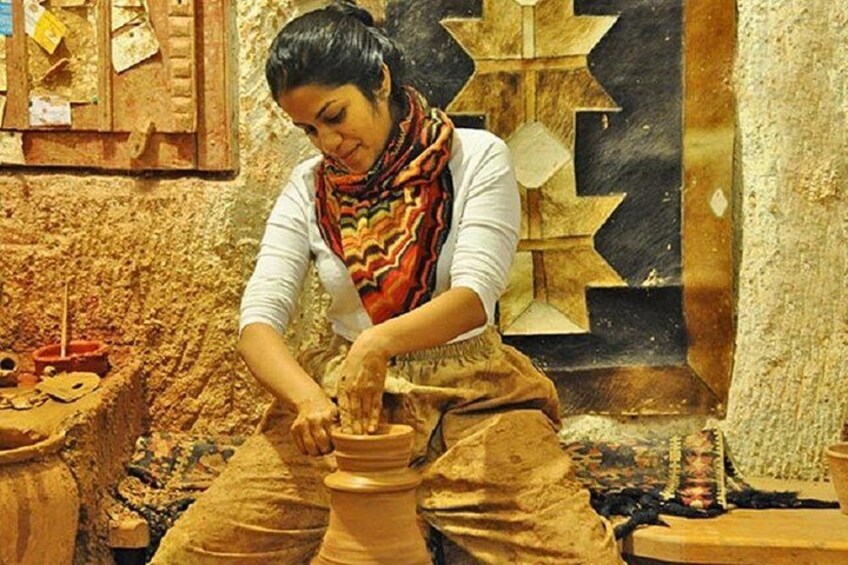 A person engaged in pottery making, surrounded by clay pots and tools. 3