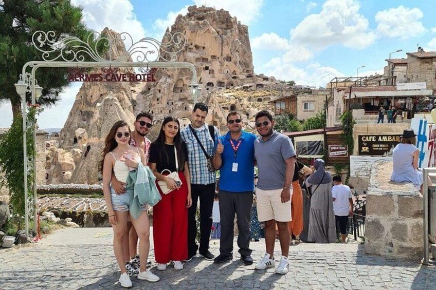 A group of people posing in front of a rock formation with a hotel sign. 2
