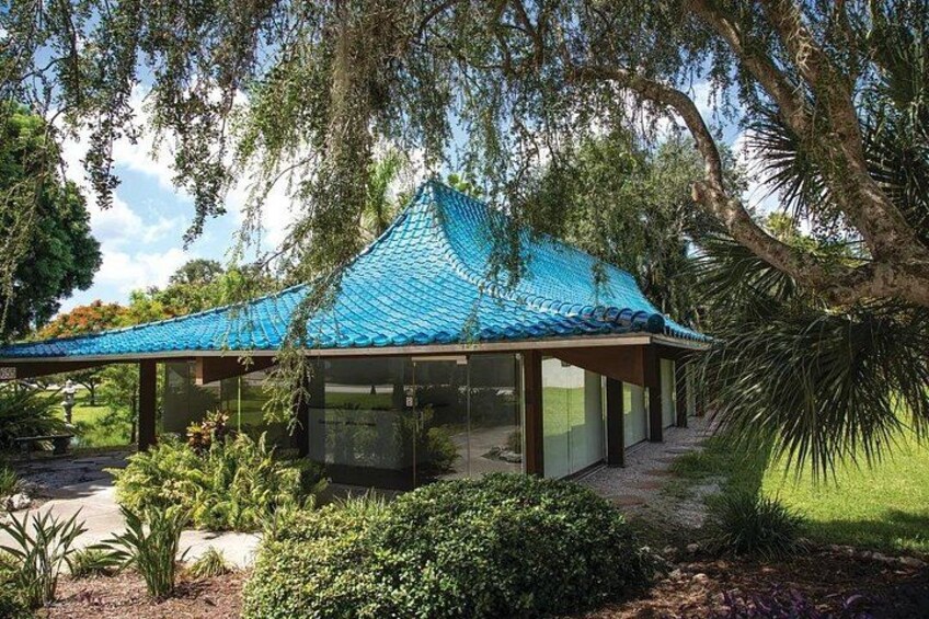 A gazebo with a blue roof, surrounded by lush greenery and trees. 2