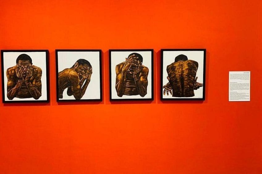 Four framed artworks on an orange wall. 4