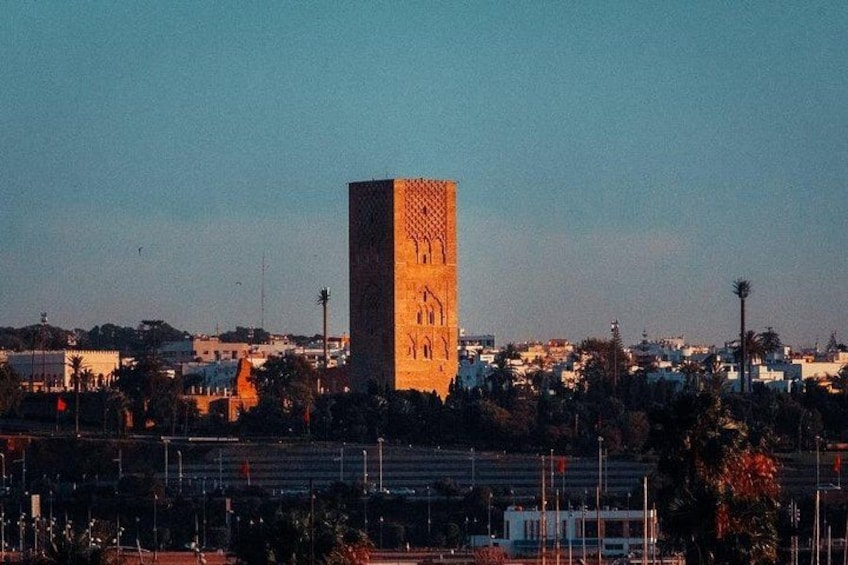 A tall, square tower with intricate patterns, surrounded by a cityscape with buildings and palm trees. 5