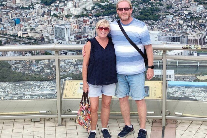 Ein Paar steht auf einem Balkon mit Blick auf eine Stadtlandschaft. 3