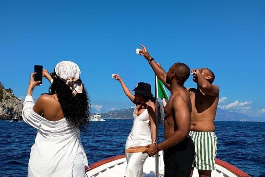 A group of people on a boat, taking a photo of a distant ship. 4