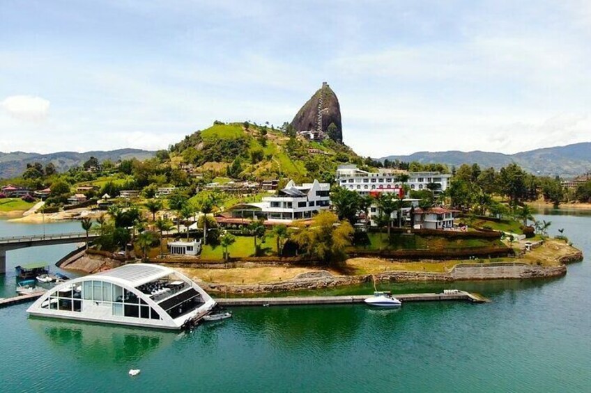 Une ville côtière dominée par une montagne imposante, avec un port de plaisance rempli de bateaux et des immeubles résidentiels. 1