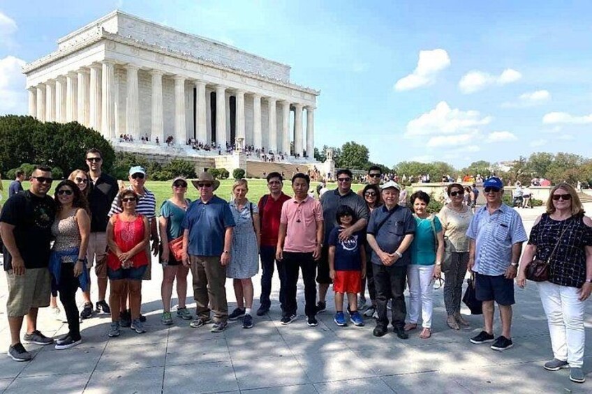 A group of people standing in front of the Lincoln Memorial. 4