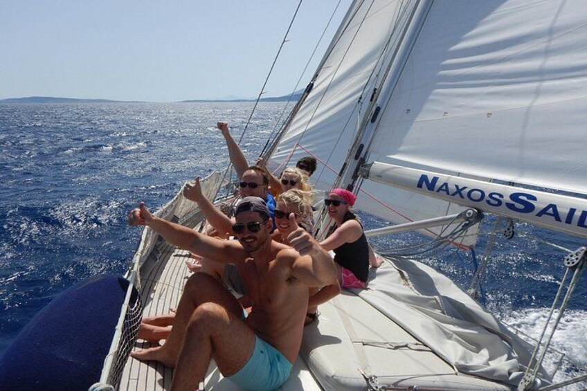 A sailboat with people on board, sailing on the ocean. 2