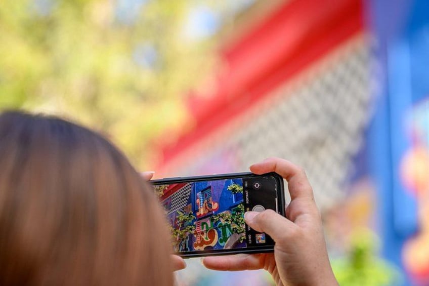 Una persona che tiene in mano uno smartphone con uno schermo colorato che mostra un gioco. 2