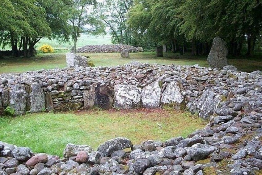 A stone circle surrounded by grass and trees. 2