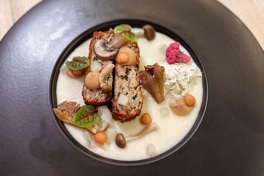 A plated dish with various food items including mushrooms, beans, and a creamy sauce. 5