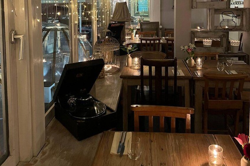 A restaurant interior with wooden tables, chairs, and candlelit ambiance. 3