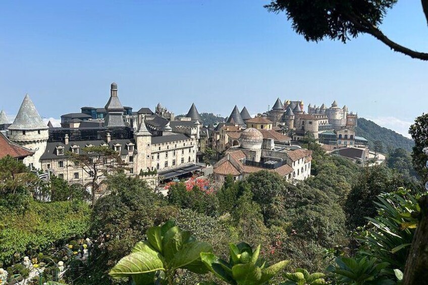A historic castle complex surrounded by lush greenery and trees. 5