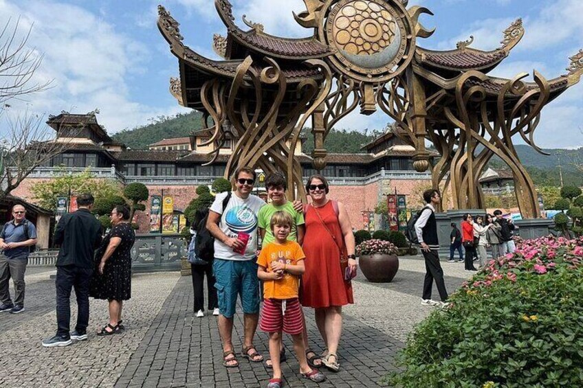 A group of people posing in front of a traditional Chinese architectural structure with intricate designs. 2