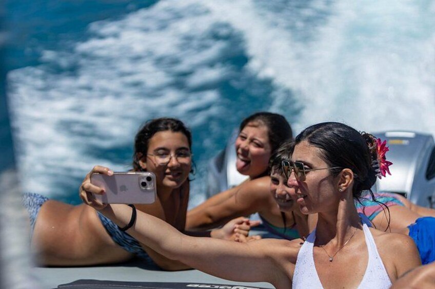 Three people on a boat with waves in the background. 1