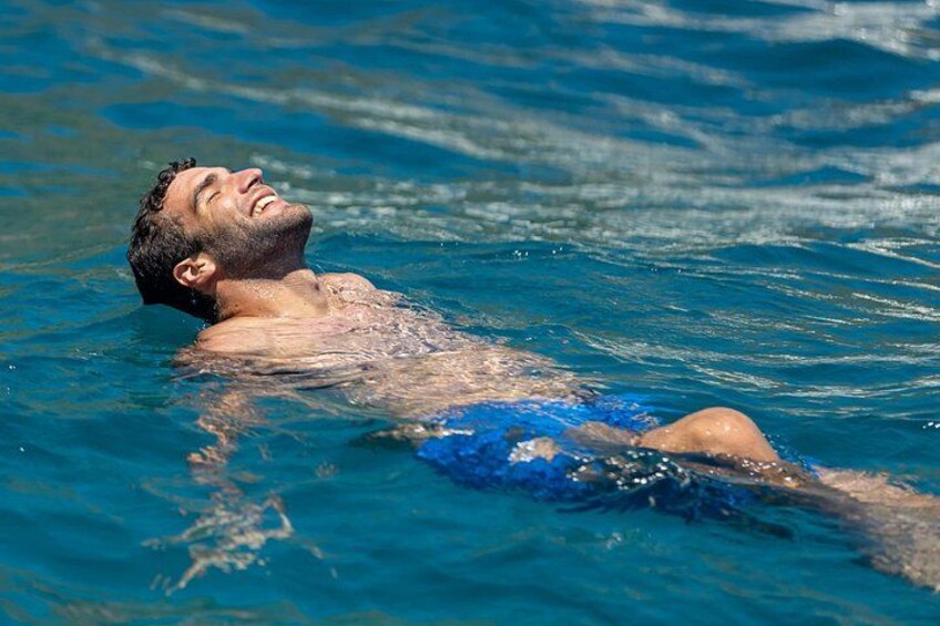 A person swimming in clear blue water. 5
