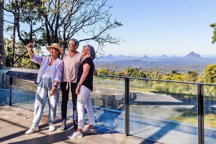 Three people taking a selfie on a balcony overlooking a scenic landscape. 1