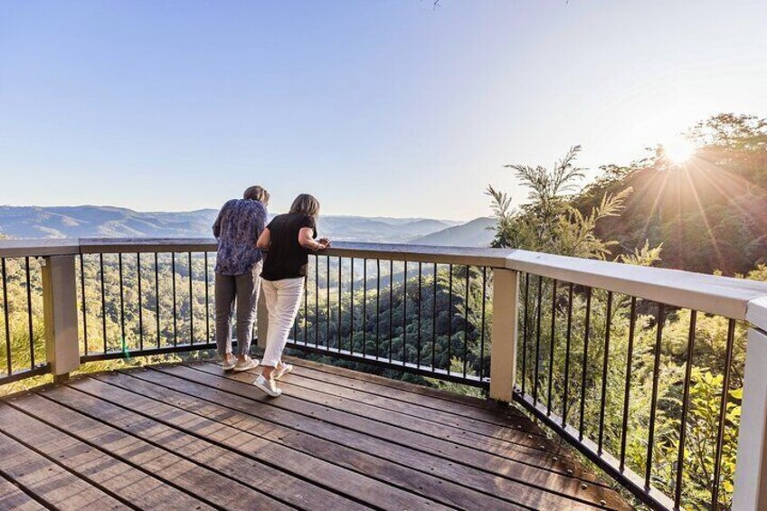 A wooden deck with a metal railing overlooking a mountainous landscape. 4