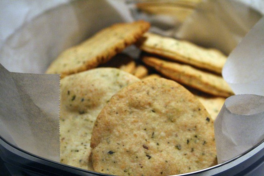 Una cesta con galletas redondas aromatizadas con hierbas. 3