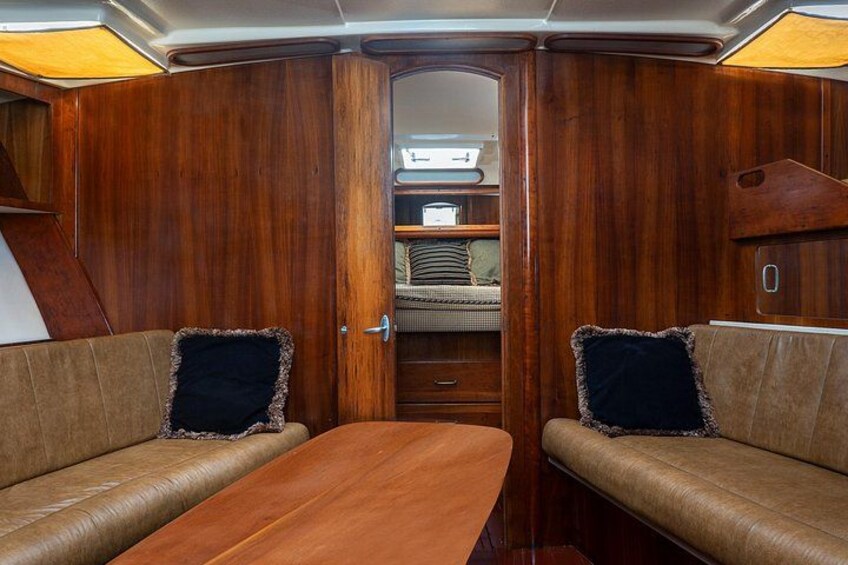 Un interior acogedor con paredes de madera, un banco acolchado y una mesa. 3
