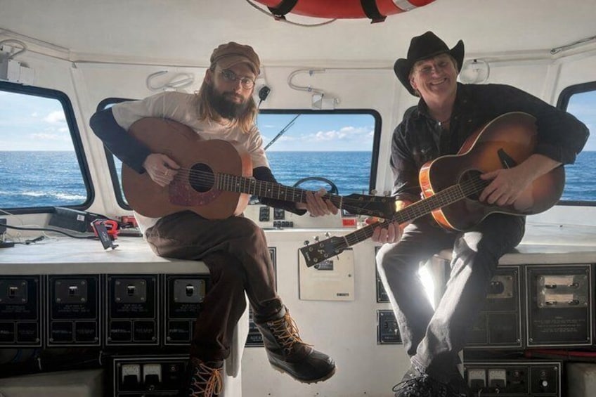 Dos personas tocan guitarras en un barco. 4