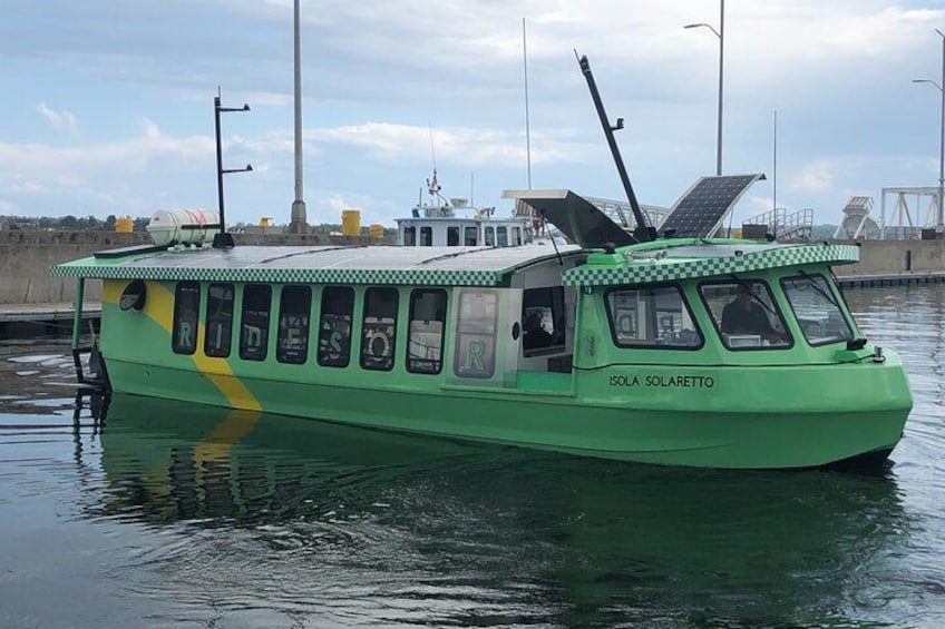 Un bateau vert, baptisé « Isola Solarettto », équipé de panneaux solaires et doté d’un toit à carreaux, était amarré dans une marina. 3
