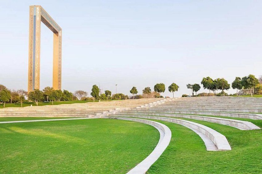 A large open space with a tall monument, green grass, and a series of steps leading up to the monument. 5