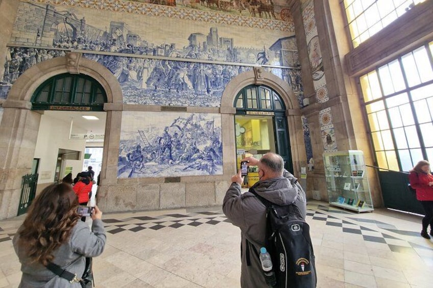 A historical building with a large blue and white mural, a glass display case, and a checkered floor pattern. 2