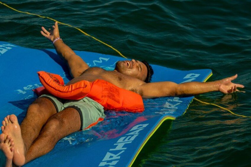 Una persona recostada sobre una tabla azul en el agua. 5