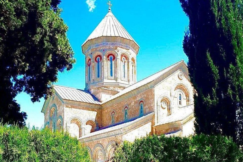 Una chiesa con una cupola imponente e finestre ad arco, circondata dal verde. 2