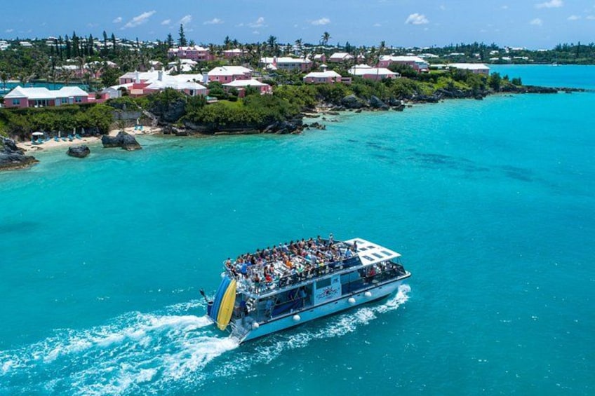 A boat with passengers, turquoise water, and a coastal town in the background. 5