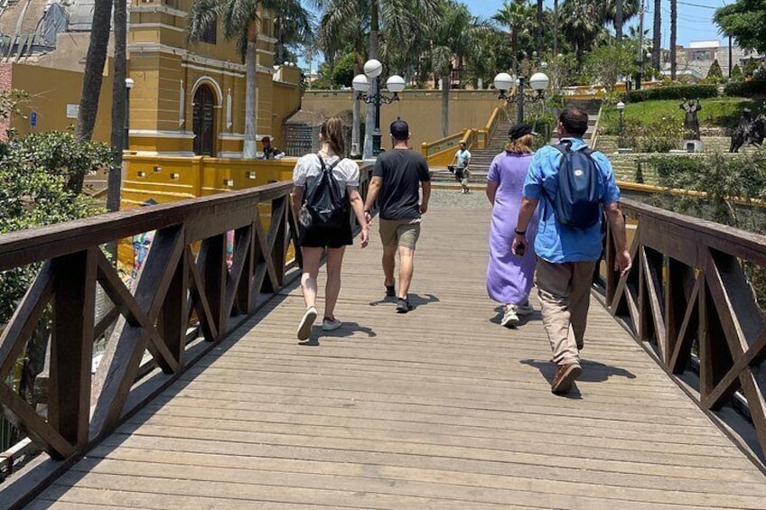 A wooden bridge with people walking on it. 1