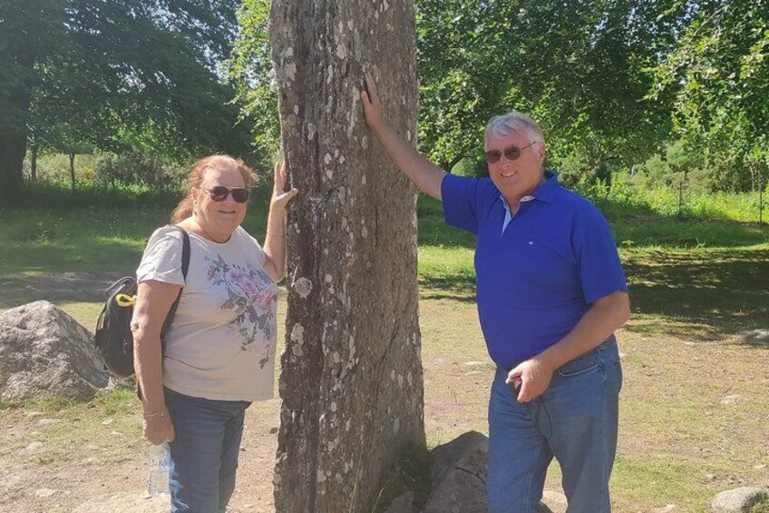 Two people standing next to a tree in a park. 2