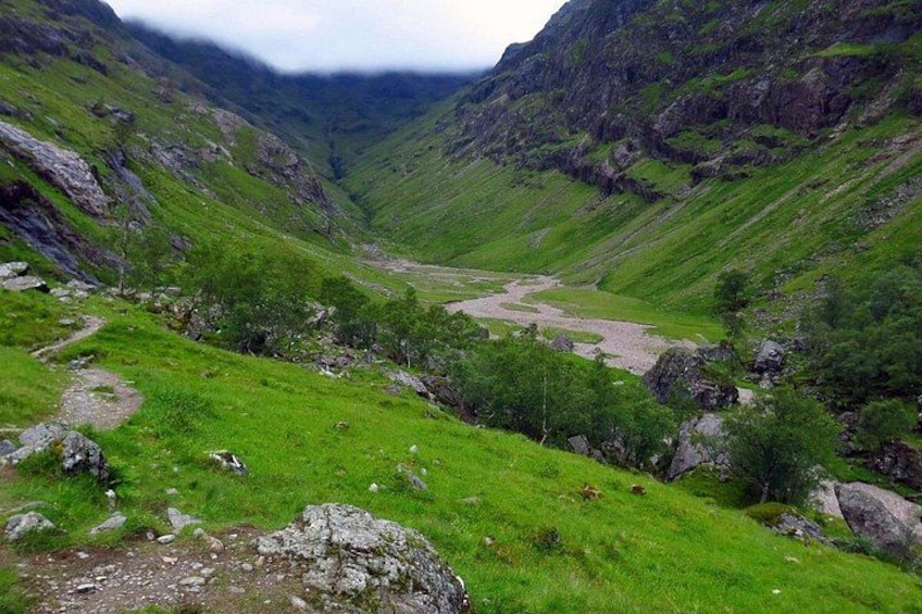 Un valle con río, terreno rocoso y vegetación verde. 5