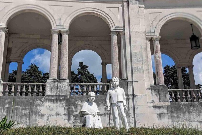 A statue of a man and a woman in front of a classical building with arches. 4