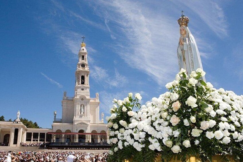 A church with a bell tower and a statue of a religious figure. 1