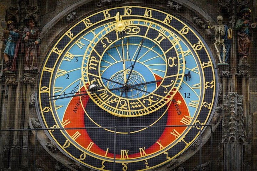 A detailed astronomical clock with zodiac symbols and Roman numerals. 4