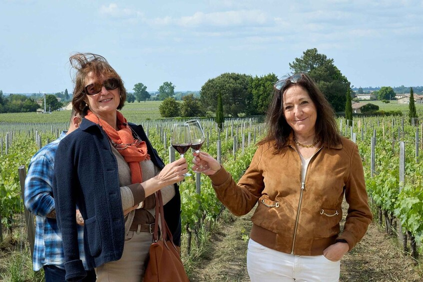 Deux personnes trinquent avec des verres de vin dans un vignoble. 2