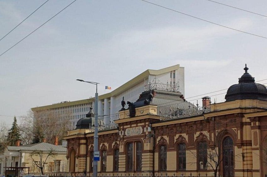 A building with classical architecture, including a dome and statues. 5