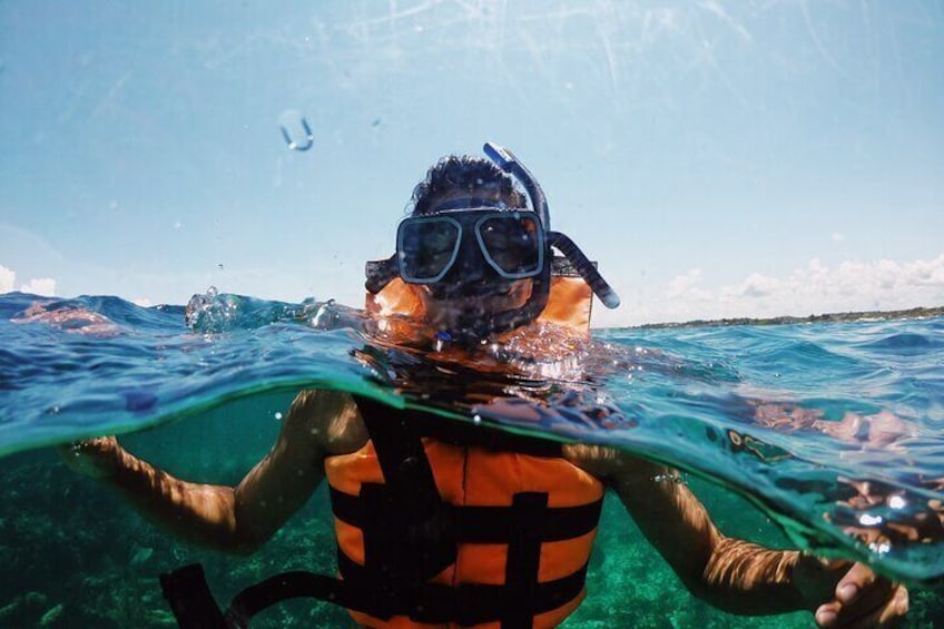 A person snorkeling underwater with a life vest. 4