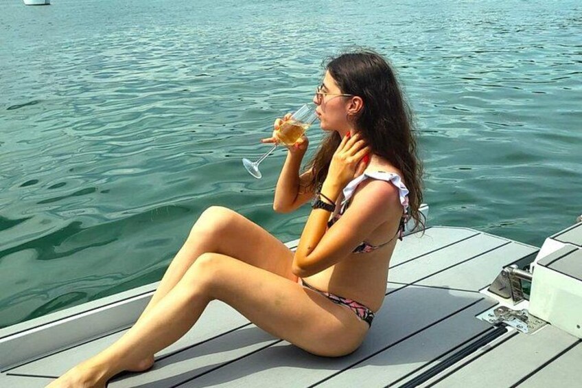 A person sitting on a boat, holding a drink. 3